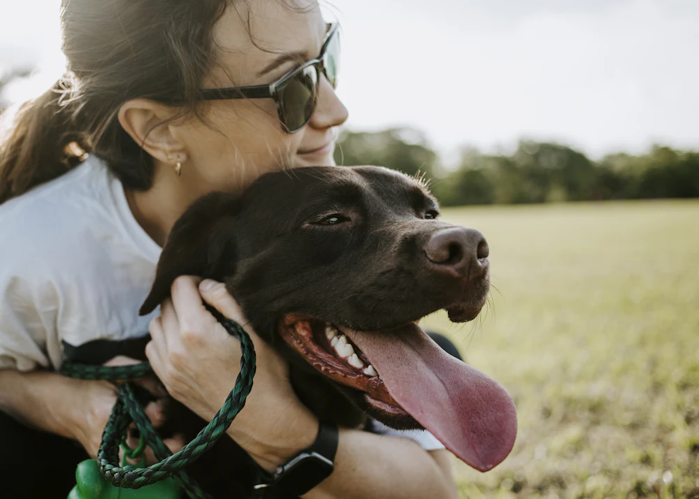 Femme serrant son chien dans ses bras